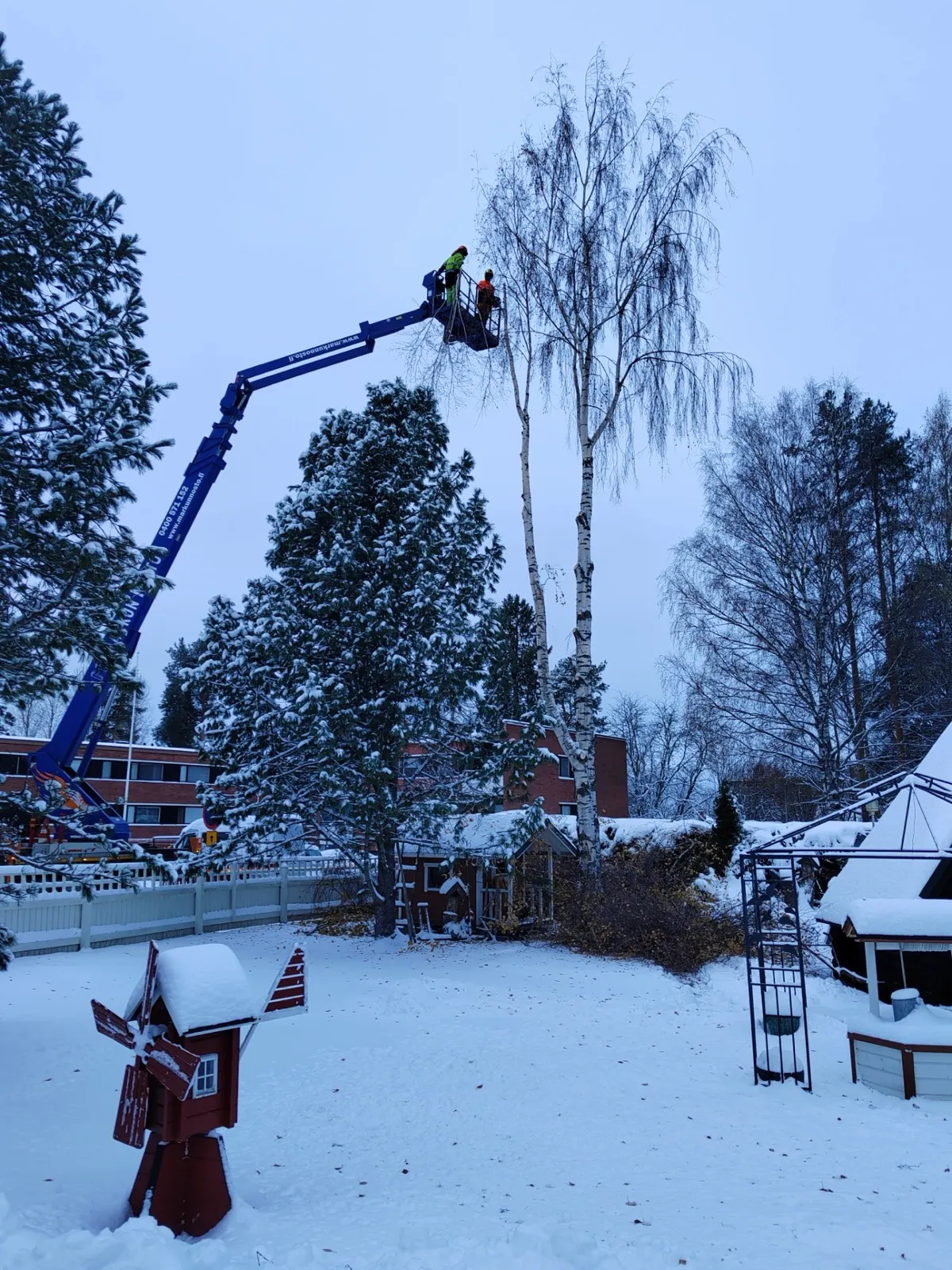 Nostokorityö lumisessa pihapiirissä